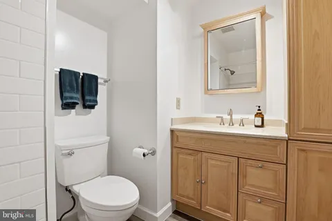 a bathroom with a toilet sink vanity and mirror