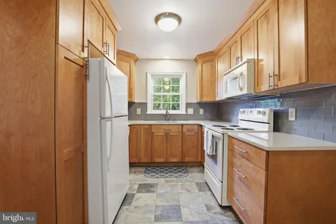 a kitchen with a sink a refrigerator and cabinets