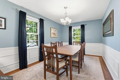 a view of a dining room with furniture a chandelier and wooden floor