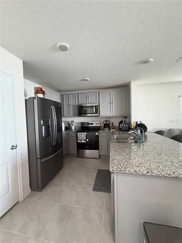 a kitchen with stainless steel appliances granite countertop a refrigerator sink and stove