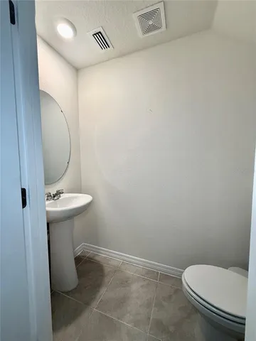 a bathroom with a sink toilet and a mirror