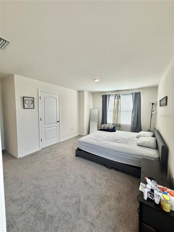 6576 Druid Way Harmony, FL 34773 - Photo 9 of 16 a bedroom with a bed and a couch