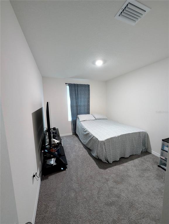 6576 Druid Way Harmony, FL 34773 - Photo 10 of 16 a spacious bedroom with a bed and a couch