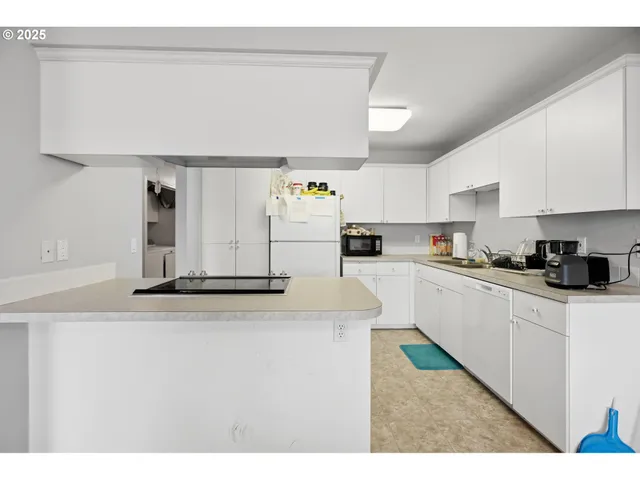 a kitchen with stainless steel appliances granite countertop a sink and white cabinets
