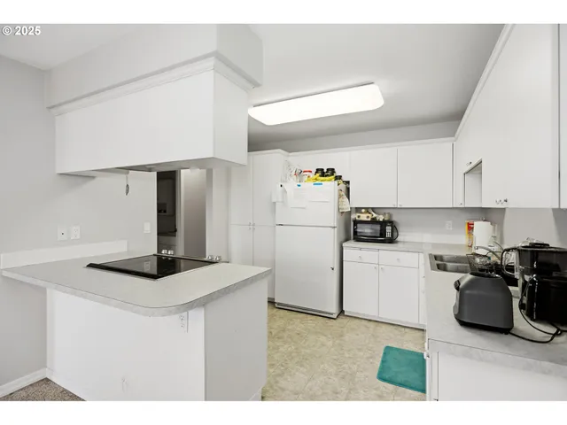 a kitchen with refrigerator a sink and a stove