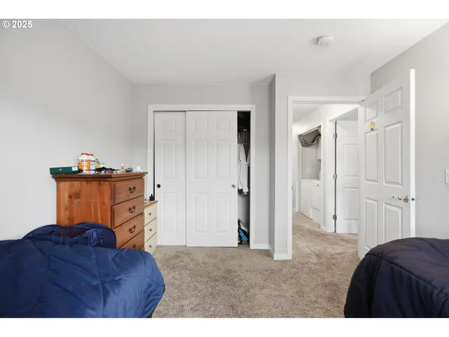 a living room with a dresser and a refrigerator