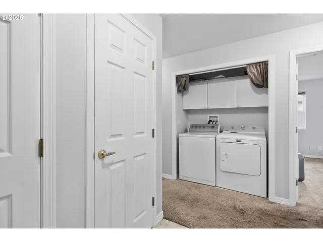 a utility room with cabinets washer and dryer