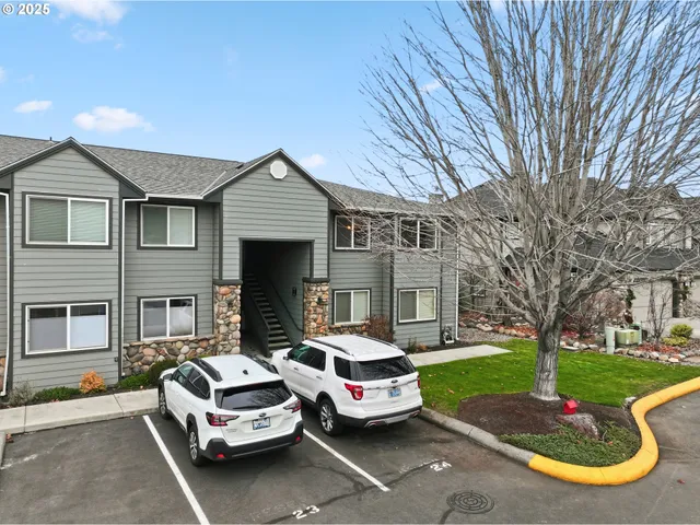 a front view of a house with a garden and trees