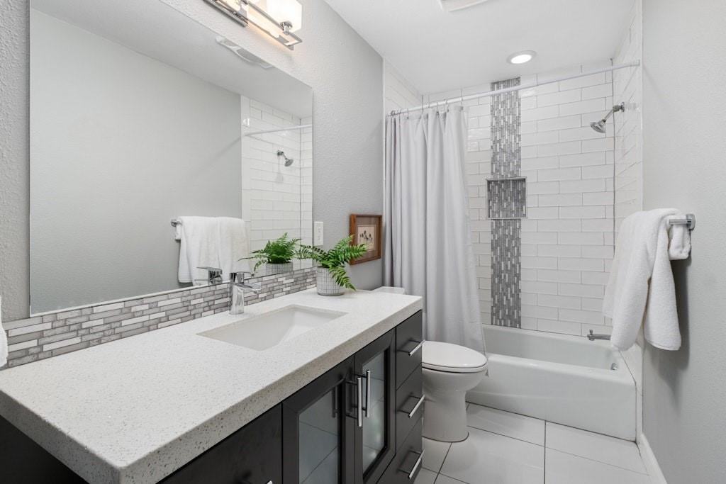 2507 Quarry Road, Unit E Austin, TX 78703 - Photo 11 of 17 Full bathroom with vanity, shower / tub combo, a textured wall, tasteful backsplash, and light tile patterned floors