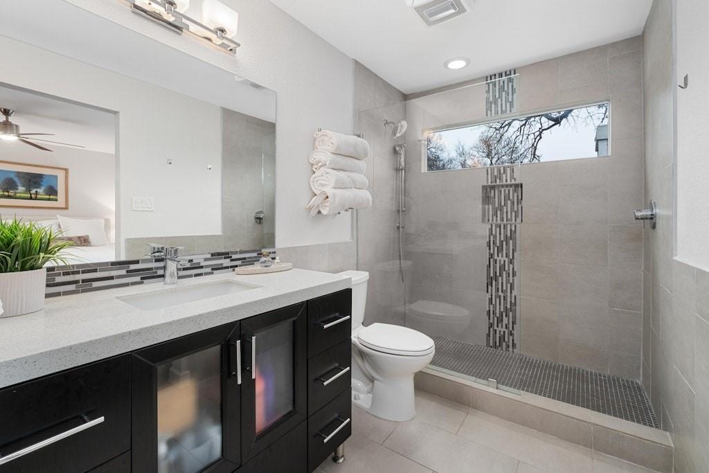 2507 Quarry Road, Unit E Austin, TX 78703 - Photo 10 of 17 Ensuite bathroom featuring vanity, a walk in shower, and light tile patterned floors