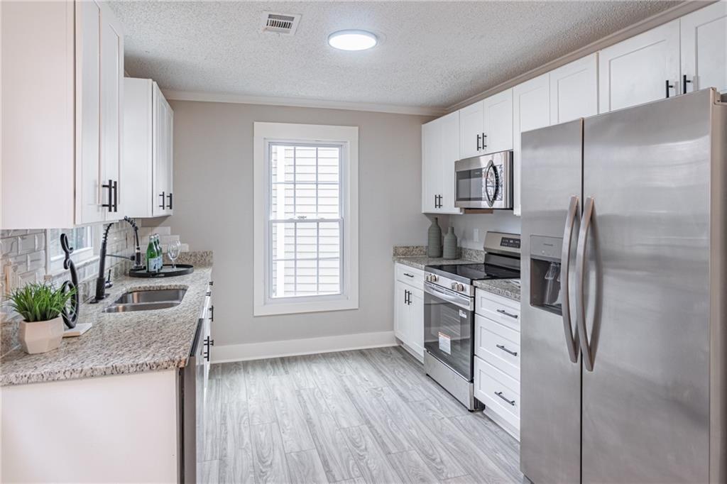 5367 Rails Way Norcross, GA 30071 - Photo 15 of 35 a kitchen with granite countertop a sink stove and refrigerator