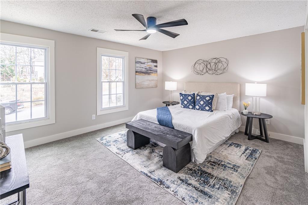 5367 Rails Way Norcross, GA 30071 - Photo 21 of 35 a spacious bedroom with a bed a table and chair