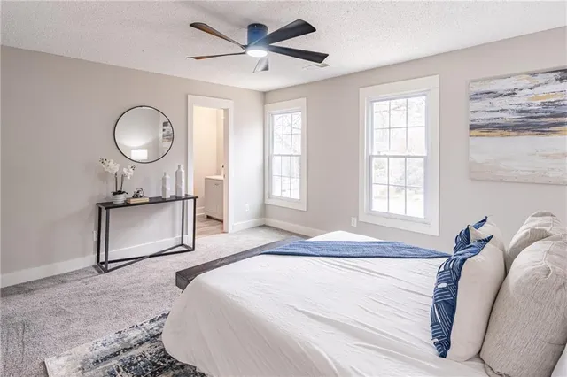 a bedroom with a bed mirror and a window