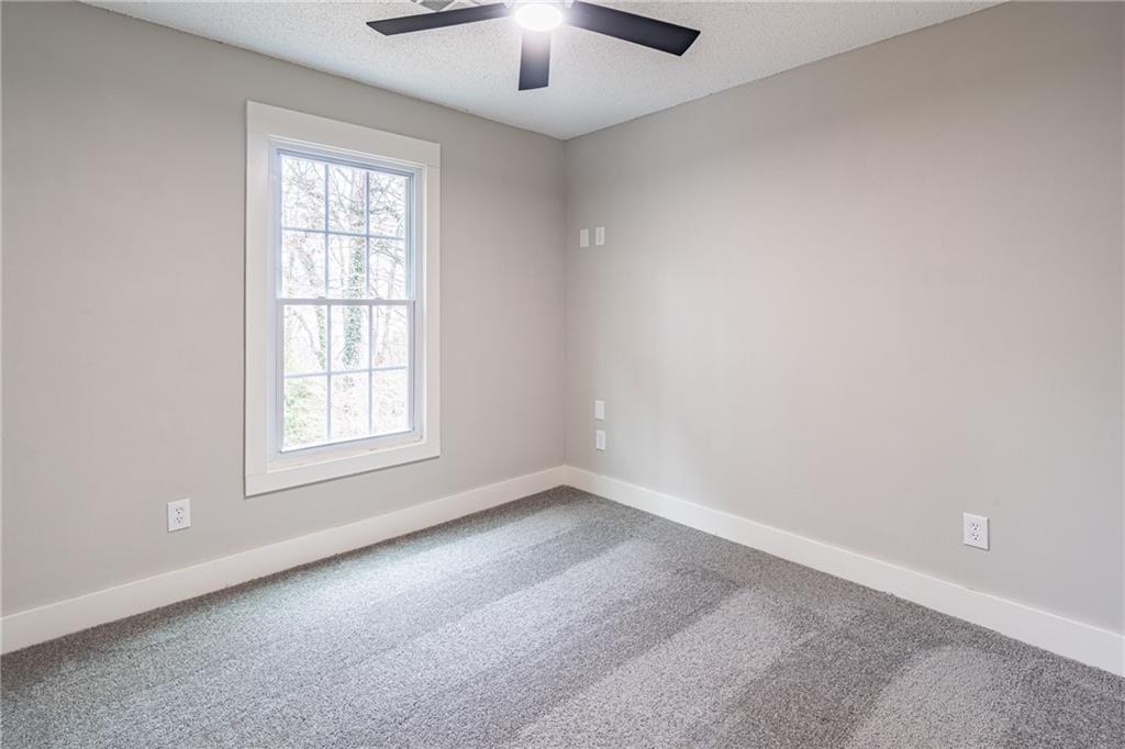 5367 Rails Way Norcross, GA 30071 - Photo 29 of 35 an empty room with chandelier fan and windows
