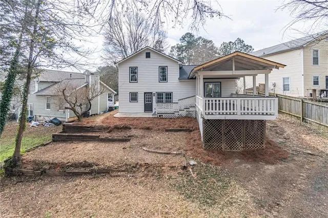 a view of a house with a yard and fence