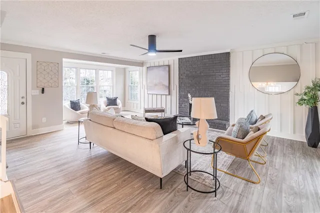 a living room with furniture a window and wooden floor