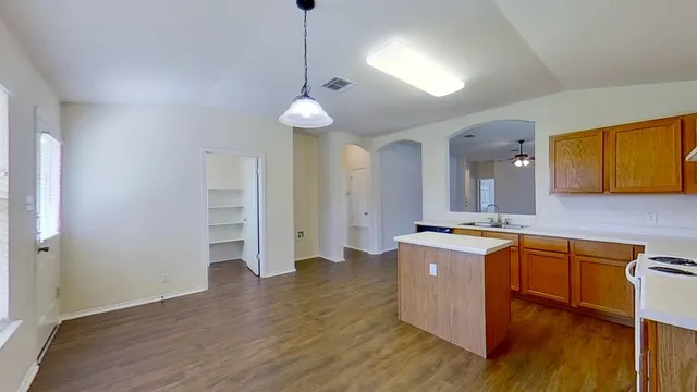 a open kitchen with stainless steel appliances granite countertop a sink a stove and a wooden floors
