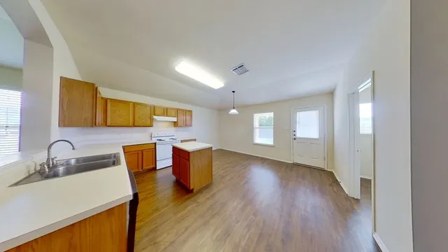 a view of a kitchen with wooden floor and a sink