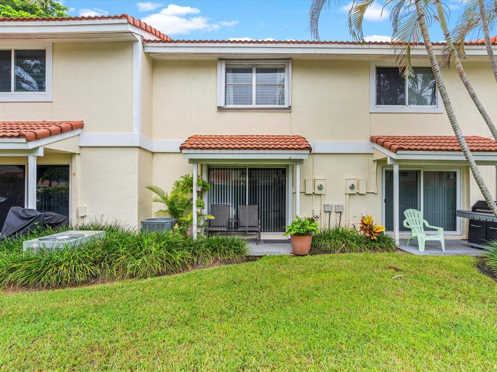 6273 Walk Circle Boca Raton, FL 33433 - Photo 20 of 25 a front view of a house with a garden and patio