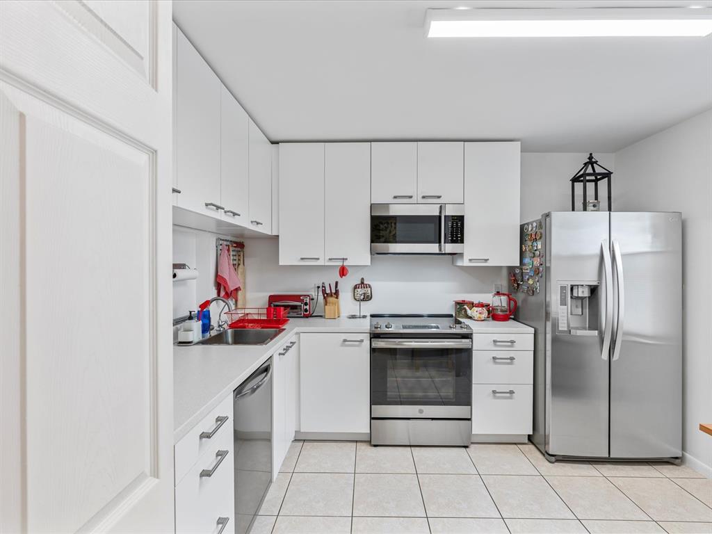 6273 Walk Circle Boca Raton, FL 33433 - Photo 3 of 25 a kitchen with stainless steel appliances a stove refrigerator sink and cabinets