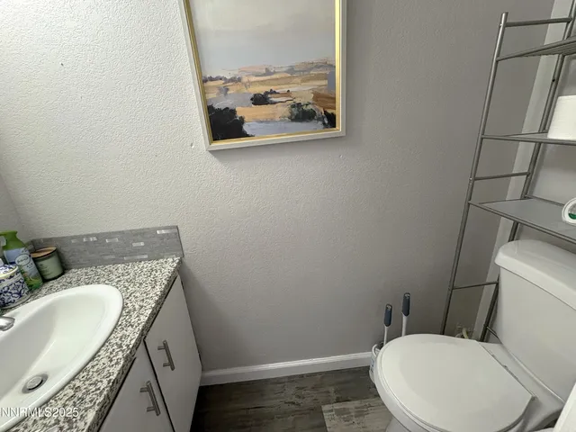 a bathroom with a granite countertop toilet and sink