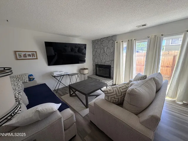 a living room with furniture a flat screen tv and a fireplace