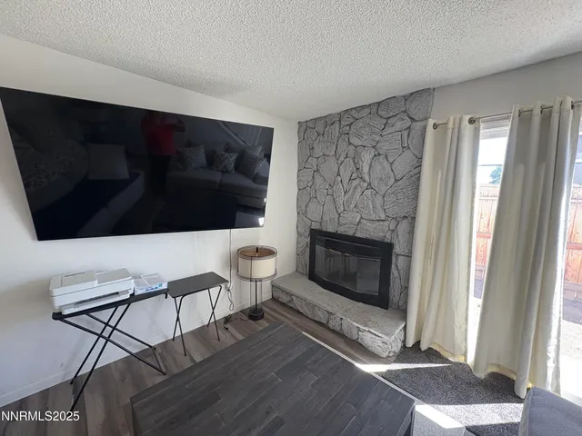a living room with a fireplace and a flat screen tv