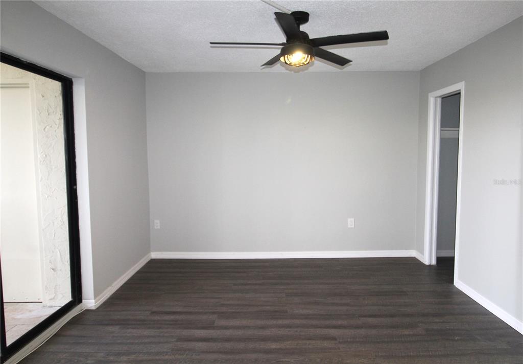 4119 61st Ave Terrace West, Unit 407 Bradenton, FL 34210 - Photo 13 of 19 an empty room with wooden floor and ceiling fan