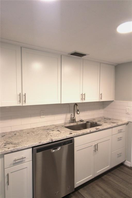 4119 61st Ave Terrace West, Unit 407 Bradenton, FL 34210 - Photo 3 of 19 a kitchen with a sink dishwasher and cabinets with wooden floor