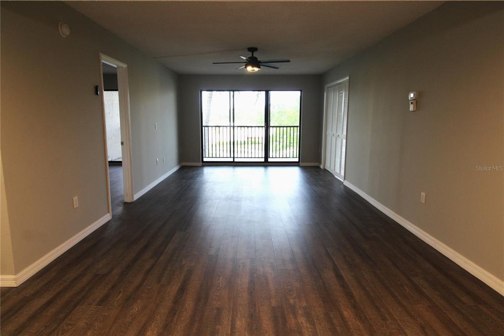 4119 61st Ave Terrace West, Unit 407 Bradenton, FL 34210 - Photo 5 of 19 a view of an empty room with wooden floor and a window
