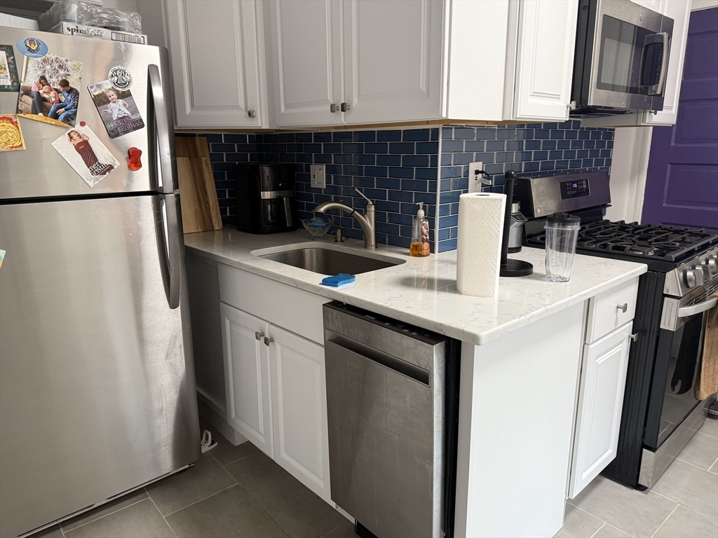36 Orkney Road, Unit 3 Boston, MA 02135 - Photo 4 of 11 a kitchen with stainless steel appliances granite countertop a sink stove and refrigerator
