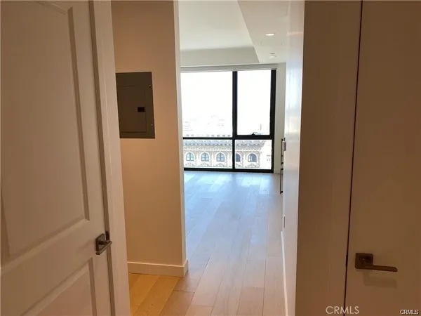 a view of an empty room with wooden floor and a window