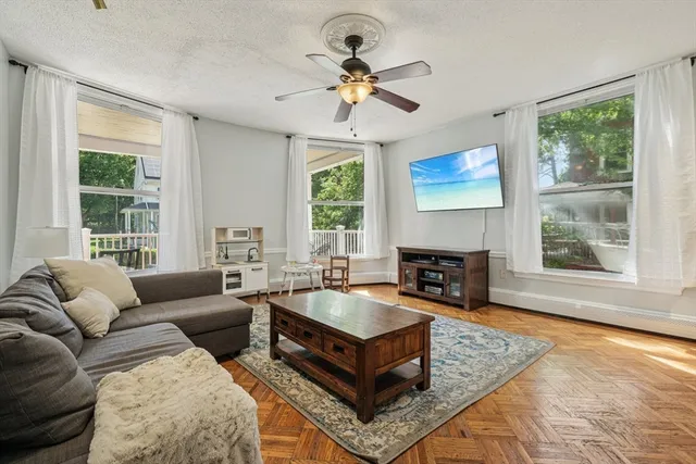 a living room with furniture a fireplace and a large window