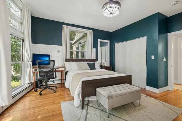 a bedroom with a bed lamps and a large window
