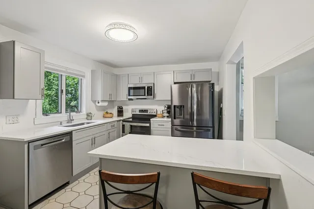 a kitchen with a table chairs sink and refrigerator