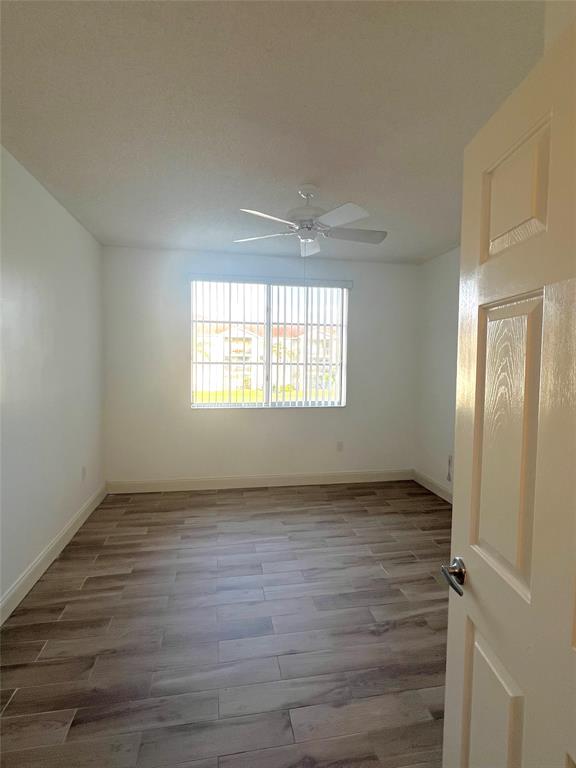 8060 North Nob Hill Road, Unit 206 Tamarac, FL 33321 - Photo 10 of 16 a view of an empty room with wooden floor and a window