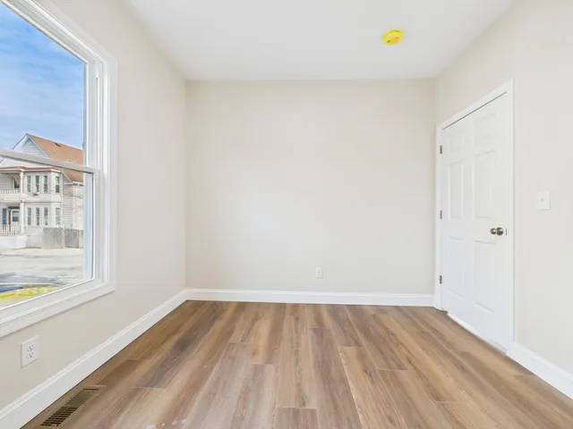 a view of a room that has wooden floor and a window