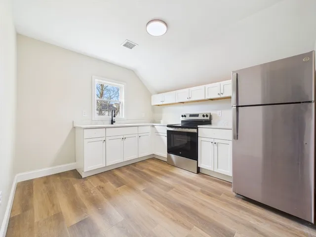 a kitchen with white cabinets and white appliances
