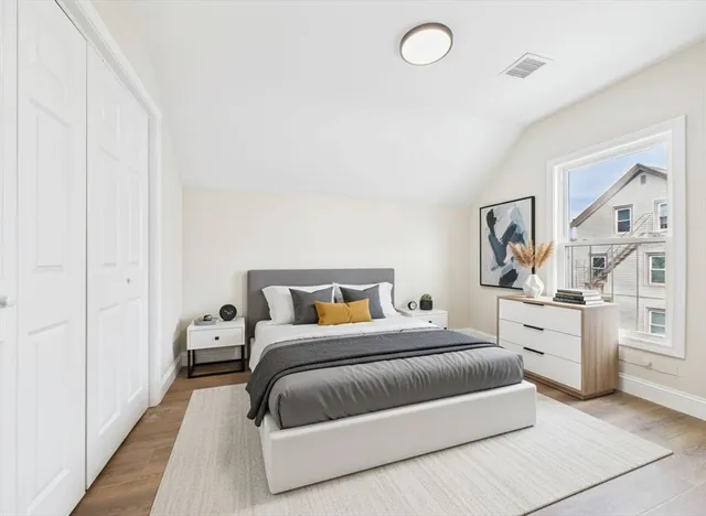 a bedroom with a white bed and white cabinets