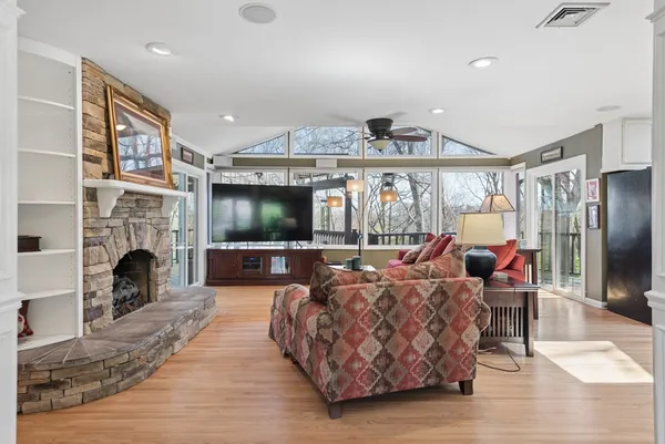 a kitchen with stainless steel appliances granite countertop a refrigerator a stove a sink a dining table and chairs with wooden floor