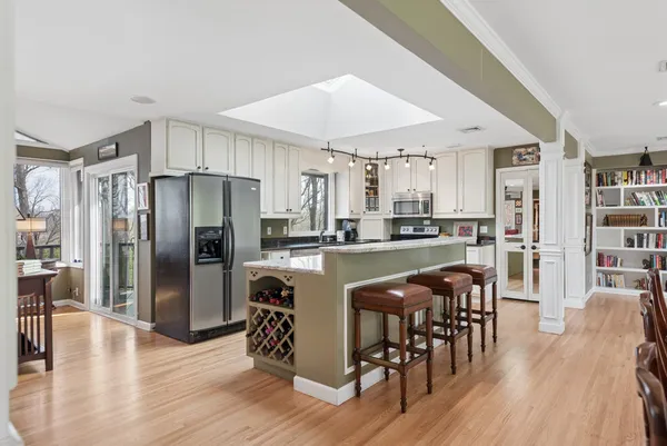 a kitchen with stainless steel appliances kitchen island granite countertop a table and chairs in it