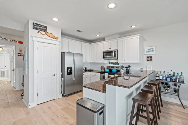 a kitchen with refrigerator a microwave a stove and wooden cabinets