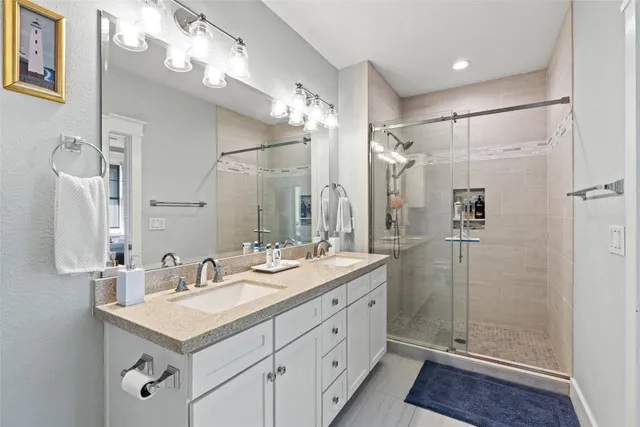 a bathroom with a shower sink double and mirror