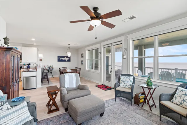 a living room with furniture kitchen view and a large window