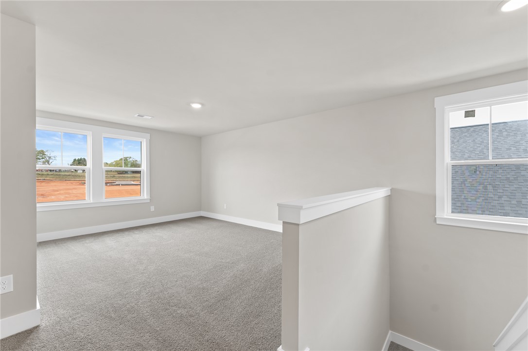 167 Tiger Lily Drive Anderson, SC 29621 - Photo 26 of 34 A spacious, naturally illuminated room boasts plush carpeting and multiple windows offering views of the surrounding landscape.