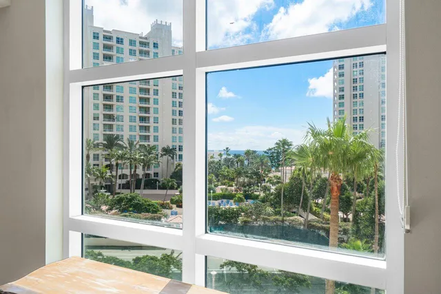a living room with furniture a large window and a dining table
