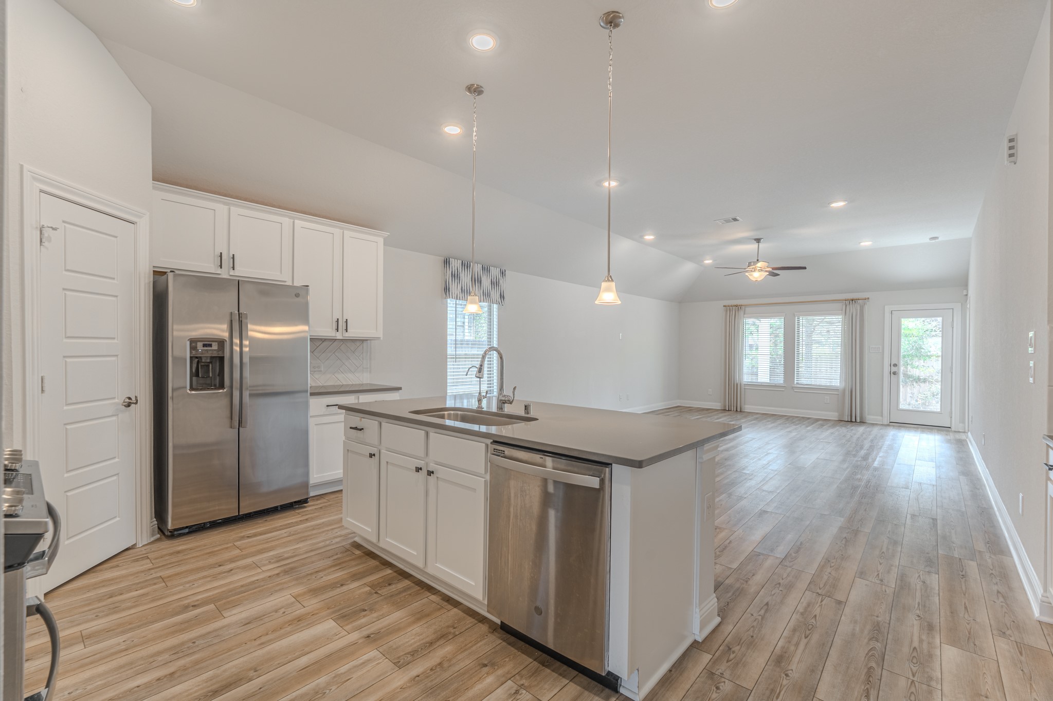 9840 Sweet Flag Court Conroe, TX 77385 - Photo 13 of 50 Showstopping kitchen features quartz countertops, oversized island seating, ample cabinetry, and a layout that connects seamlessly to the main living space.