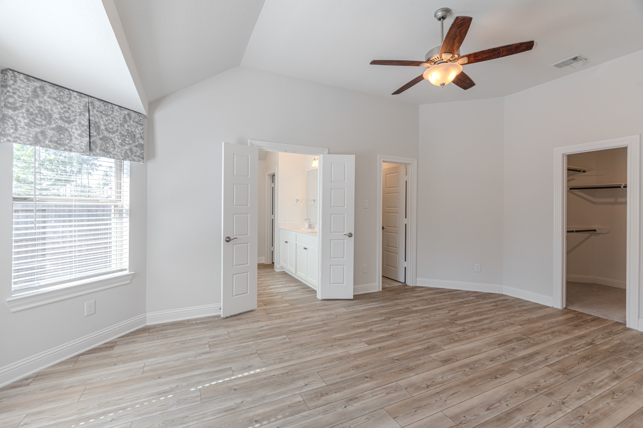 9840 Sweet Flag Court Conroe, TX 77385 - Photo 25 of 50 Private primary suite offers a peaceful retreat with high ceilings, luxury vinyl plank flooring, and plenty of room to unwind in comfort.