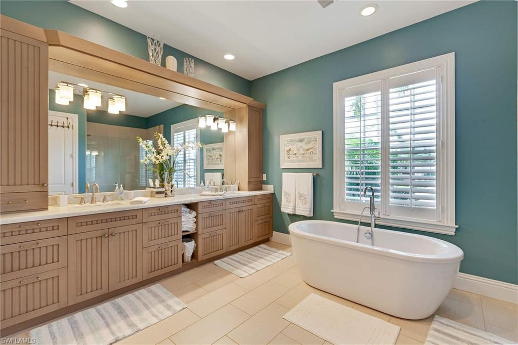 150 Central Avenue Naples, FL 34102 - Photo 12 of 35 a large white tub sitting in a bathroom next to a window