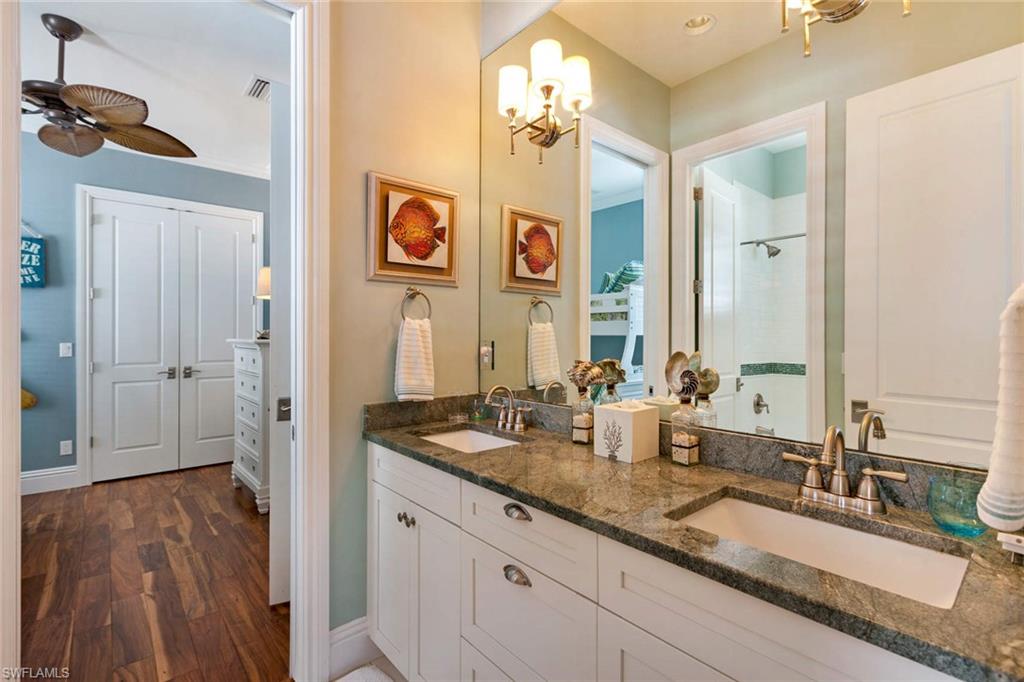 150 Central Avenue Naples, FL 34102 - Photo 15 of 35 a bathroom with double vanity sinks and a mirror